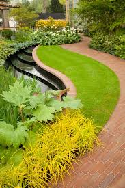 Beautiful Garden Design With Curvaceous Lines And Plants Including Wild Ginger And Pretty Rhododendron Macabeanum Garten Garten Ideen Gartengestaltungsideen