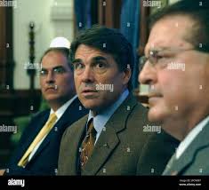 Texas Gov. Rick Perry, center, responds to a question during a news  conference Wednesday, Aug. 23, 2006, in Austin, Texas. Perry is preparing  to host other governors from U.S.-Mexico border states in