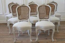Each dining chair features a synthetic cane back with an upholstered seat, creating a charming farmhouse look. 6916canechairs1 Jpg 850 566 Pixels Leather Dining Room Chairs White Leather Dining Chairs French Dining Chairs
