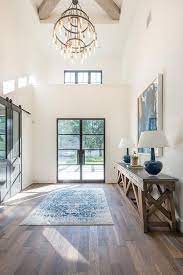 Statement Chandelier Draws The Eye Up To The Beautiful X Wood Beam Ceiling Design In Modern Farmhouse Interior Design Farmhouse Interior Design Foyer Design