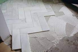 There is a large variety of tile flooring to choose from, and it can be a little intimidating to know where to start. Try This Herringbone Marble Tile A Beautiful Mess Herringbone Marble Herringbone Marble Floor Marble Tile Bathroom Floor