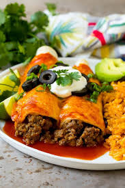 A Plate Of Beef Enchiladas Topped With Sour Cream Olives And Green Onions Beef Enchilada Recipe Beef Enchiladas Enchilada Recipes