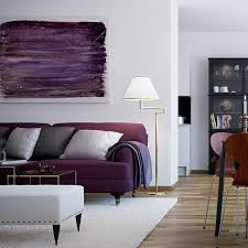 In True Scandinavian Style The Walls Remain A Vast White Canvas On Which Colorful Splashes Of Modern Art Purple Living Room Living Room Decor Purple Sofa
