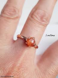 An uncut, unpolished stone containing what appears to be sunstone. Sunstone Ring Raw Orange Gemstone Adjustable Ring 1 35ct Etsy Sunstone Jewelry Orange Gemstone Raw Stone Engagement Rings