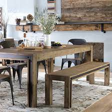 Rustic setting for a stylish dining room furnished with a rectangular dining table made out of reclaimed wood with a primitive, unfinished look. Dining Room Sets With Bench Living Spaces