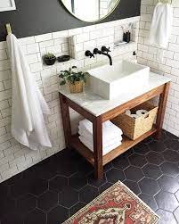 Bathroom interior with black hexagon tile and concrete walls, a large angular tub and a double sink on a wooden shelf. Marble Vanity And Black Hex Tile Small Bathroom Remodel Bathroom Remodel Master Bathrooms Remodel