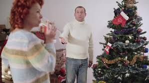 Wewill christmas tree xmas tree artificial 6ft with decorated pinecones and red berries natural white pine for christmas decoration christmas parties, stable metal stand, easy assembly. Portrait Of Nervous Caucasian Man Decorating Christmas Tree As Blurred Woman Drinking Champagne At By Hightfilm
