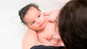 Use your nondominant arm to support your baby's head and neck and the other to hold and guide your baby's body into the water, feet first. Safe Baby Bath Temperature Raising Children Network