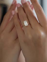 An emerald cut diamond engagement ring is enhanced by a pave diamond halo. Pin On Engagement Rings Diamond Rings