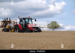 Kelso, Scotland, 25 July 2018. Crop Spraying in Scottish Borders Alistair Stewart,  farmer, spraying an oat crop ahead of cutting in ten days time, near Kelso  in the Scottish Borders,