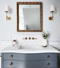 Bathroom With Brass Accents Light Grey Walls White Tile And Blue Grey Vanity Blue Bathrooms Designs Bathroom Design Blue Bathroom