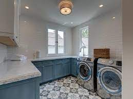 The space doubles as a playroom and craft space for grandchildren. White And Blue Laundry Room Cabinets Transitional Laundry Room