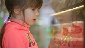 Little girl choosing cake at grocery store