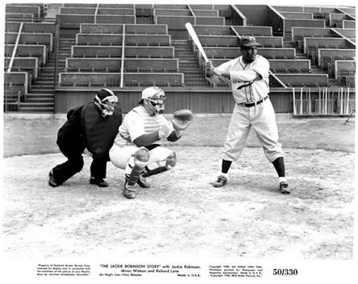 Film still from The Jackie Robinson Story showing Jackie Robinson (as  himself) at bat, with catcher and umpire behind the plate]