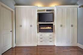50% wardrobe closet, 50% entertainment center. This Custom Built In Wall Unit Multi Tasks And Looks Beautiful