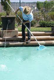 Swimming Pool Cleaner Man Cleaning Out The Swimming Pool With A Net Affiliate Cleaner Man Swimmin Swimming Pool Cleaners Swimming Pools Pool Cleaning