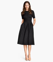 Black Knee Length Dress In Textured Jersey With Short Sleeves Seam At Waist Flared Skirt With Pleats At Top And Concealed Zip At Back Unline Met Afbeeldingen Jurken Kleding