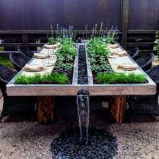 A patio table is made from cedar and has a rectangular planter sunken into the middle. 15 Planter Tables To Refresh Your Space Shelterness