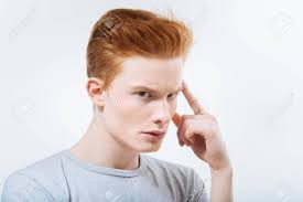 Earnest Serious Pleasant Guy Touching His Temple And Looking At The Camera  While Considering Stock Photo, Picture and Royalty Free Image. Image  94365600.