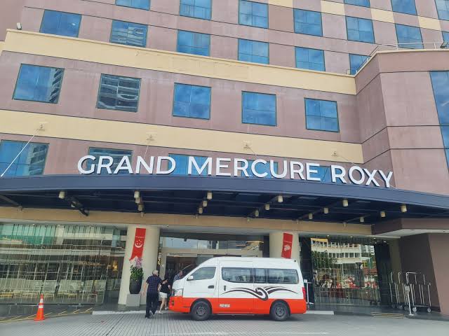 Entrance to the hotel with a van out the front
