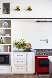 White Kitchen Cabinets Painted Benjamin Moore Cloud Cover The Red Italian Range Adds A Punch Farmhouse Kitchen Colors Kitchen Color Red Kitchen Decor Wall Art