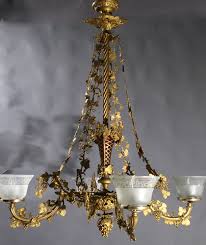 It begins with an understated canopy and chain, coming down to a loop finial and flower cup with five attached chains. Genuine Antique Lighting 4 Light Rococo Revival Chandelier
