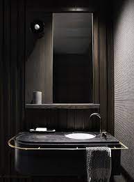 Modern Bathroom Space With Dark Wood Panels A Black Marble Counter And A Large Mirror Bathroom Decor Modern Bathroom Interior Design Awards