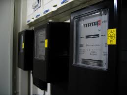 Medidor de consumo eléctrico y bombilla LED en mano