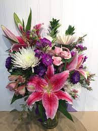 A Gorgeous Arrangement Of Star Gazer Lilies Fuji Mums And Asters Flower Arrangements Modern Floral Arrangements Tropical Floral Arrangements