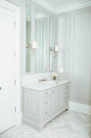 This slick, light herringbone pattern floor works nicely with the deeper brown found in the modern dresser. Light Gray Washstand With Honed White Marble Herringbone Floor Tiles Transitional Bathroom