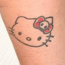It is sitting on a broom stick with a cute purple cape on its back. 10 Celebrity Hello Kitty Tattoos Steal Her Style