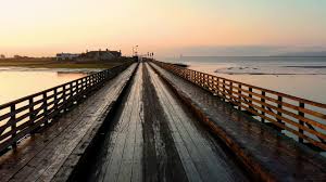 The rock climber is free climbing a tall eroded column rock formation, climbing high up, close to other rock columns under a beautiful dawn sky. Wooden Bridge Beach View High Resolution Copyright Free Youtube