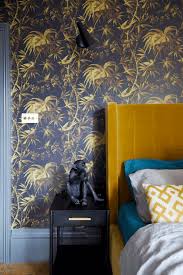 A modern graphite grey bedroom with a white bed, lights and photos and lemon yellow bedding to spruce up the space. 35 Yellow Bedroom Ideas