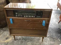 This gorgeous turntable is designed with the wood panels and sleek silver buttons of classic electronics, but it's outfitted with today's features. Vintage Mid Century Record Player Cabinet Movie Prop Rentals