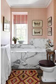 A round mirror was used to play up the circular elements in the room, and pale blue pendants draw the eye to the area. Small Bathroom Ideas And Designs House Garden