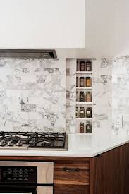 Behind this gorgeous sliding marble backsplash is a hidden spice rack. Spice Rack Plano Contemporary Kitchen Also Clever Concealed Cooktop Hidden Behind Backsplash Hidden Spice Rack Integrated Spice Rack Modern Kitchen Modern New York Kitchen Multi Function Organization Spice Rack Stone Tile Vent