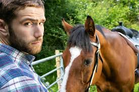 Beau Cowboy, Cavalier à Cheval En Selle, à Cheval Et Avec Des Bottes Photo  stock