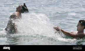 Australian cricket players Shaun Tait, right, and Brad Hogg relax in the  water