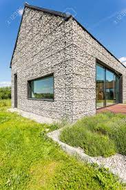 Stone masonry build an enduring and endearing home of stone. Modern Pebble Stone Wall House With Large Windows Surrounded Stock Photo Picture And Royalty Free Image Image 82517782