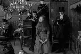 Anne-Marie Malik (Alice) and Eric Idle (among others) in the courtroom  scene from Jonathan Miller's 1966 Ali…