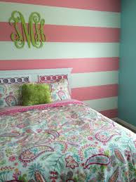 A floor bed lighted by a pair of industrial pendants along with a wooden side table and a fuchsia pink bean bag filled this primary bedroom. Pink And Green Striped Wall Novocom Top