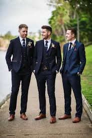 Groom in navy shawl lapel tuxedo + groomsmen in black shawl lapel tuxedos + groomslady in black shawl women's tuxedo. Burgundy And Blue Cathedral Wedding With A Modern City Reception Hey Wedding Lady