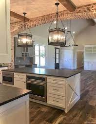 The wood kitchen island countertop, desaturated green/gray cabinets, oversized farmhouse sink, and black paneled window frames give this space a laid back feel. Farmhouse Style Kitchen Islands