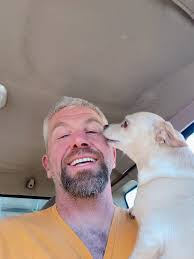 owner of black chiweenie and blond dog