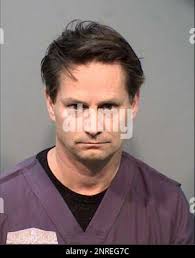 This undated booking photo provided by the Arizona Attorney General's  Office shows Dr. Michael Lee Ham. The ophthalmologist and eye surgeon who  runs clinics in metro Phoenix and the Prescott area has