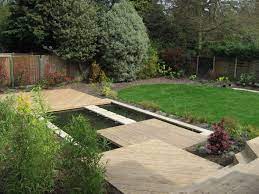 Sloping Away From The House In This Small Garden The Slope Was Managed By Creating A Series Of Timbe Sloped Backyard Landscaping Sloped Garden Sloped Backyard