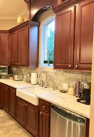 Cherry cabinets have been a staple in rustic, traditional, and modern kitchen designs for many years. Cherry Kitchen Tumbled Travertine Backsplash With Maestro Quartz Brown Kitchen Cabinets Kitchen Renovation Replacing Kitchen Countertops