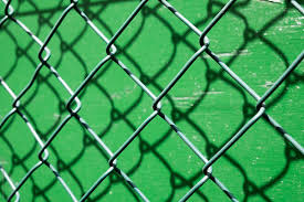 Steel bars stacked for construction, roped with metallic wire and marked with white paint stacked old wire mesh fence with hole in winter rural garden. Chain Link Fence Against Bright Green Paint By Jon Attaway Metal Fence