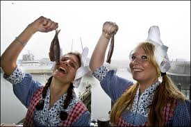 Bij het inkopen van de hollandse nieuwe wordt nauwkeurig gekeken naar. This Picture Shows Two Dutch Girls About To Eat A Hollandse Nieuwe Translates As Dutch New One Every Year The Dutch Start Dutch Girl Picture Show Style