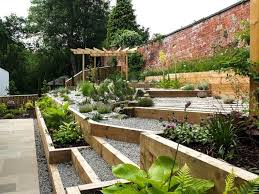 A vegetable garden on a steep slope is a great place to add vines. Amazing Ideas For Sloping Gardens Turn The Slope Into An Advantage My Desired Home Sloped Garden Modern Garden Garden Ideas Uk